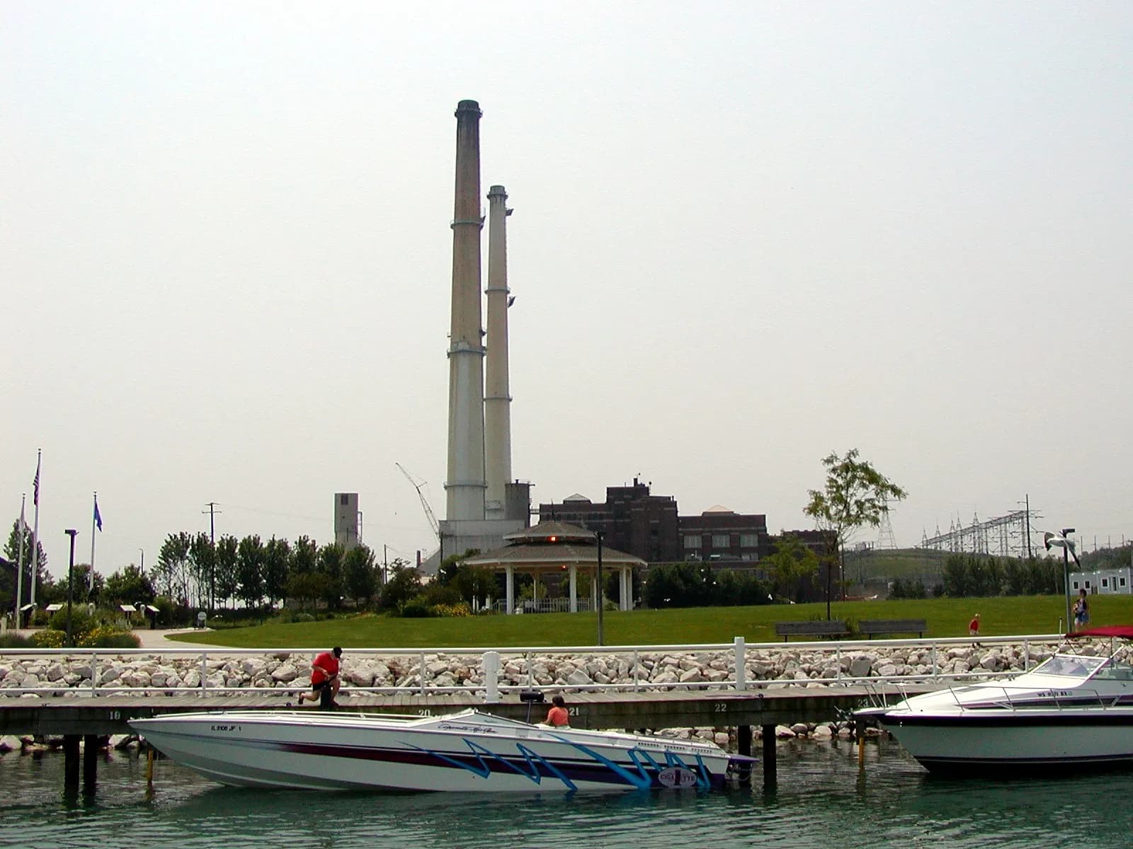 The Port Washington, Wisconsin power plant stack seen across the harbor with boats