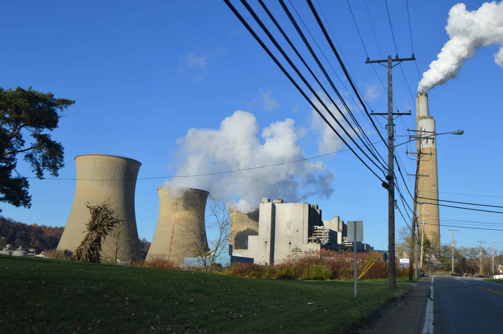 Cooling towers and a tall stack at the power plant in Shippingport, Pennsylvania, behind power lines